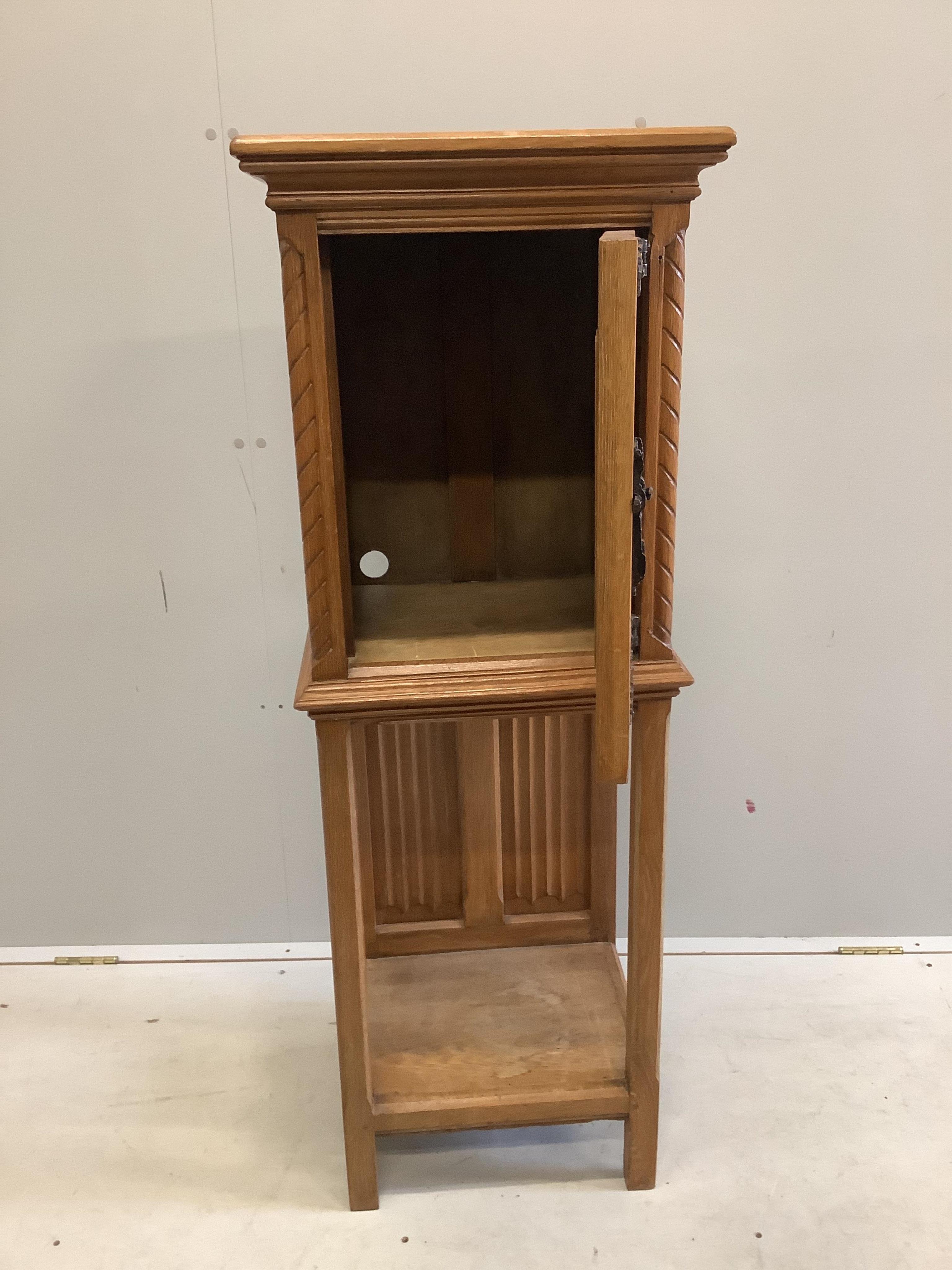 A Gothic Revival oak cabinet on stand, width 46cm, depth 38cm, height 127cm. Condition - fair